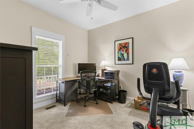 carpeted home office with ceiling fan, visible vents, and a healthy amount of sunlight