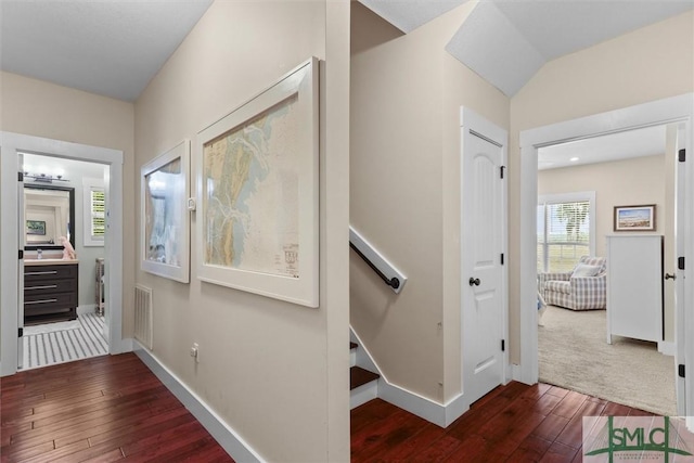 corridor with baseboards, dark wood finished floors, and visible vents