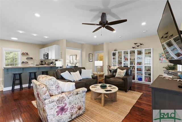 living area featuring a ceiling fan, recessed lighting, and dark wood-type flooring