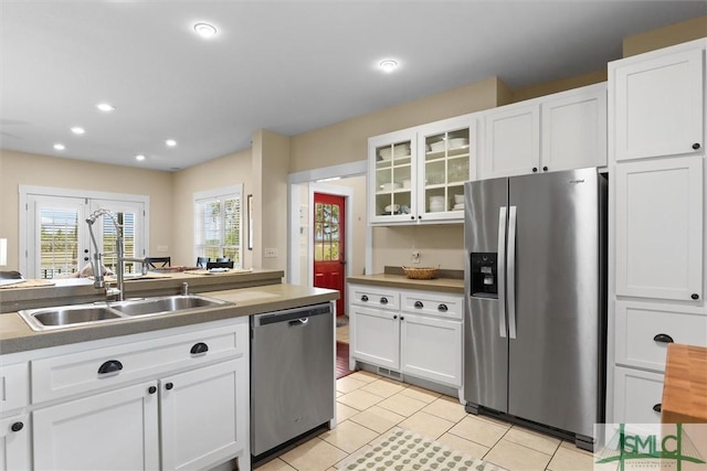 kitchen featuring white cabinets, stainless steel appliances, and a sink