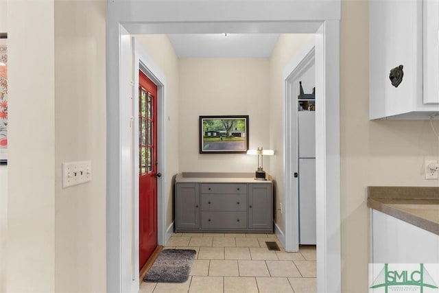 hall with light tile patterned flooring, baseboards, and visible vents