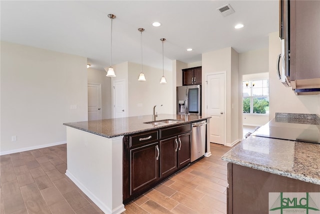 kitchen with a sink, appliances with stainless steel finishes, light wood-type flooring, and dark brown cabinets