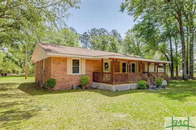 view of front of house featuring covered porch, brick siding, and a front yard