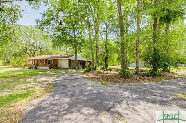 ranch-style home featuring covered porch and aphalt driveway