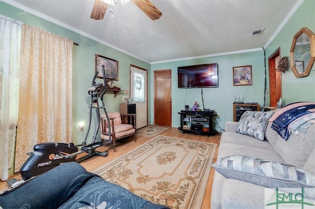 living room featuring visible vents, ornamental molding, ceiling fan, and wood finished floors