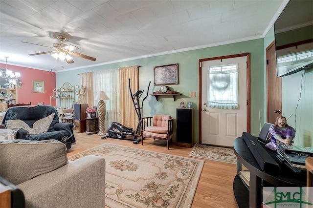 living area with light wood-style floors, plenty of natural light, ceiling fan with notable chandelier, and crown molding