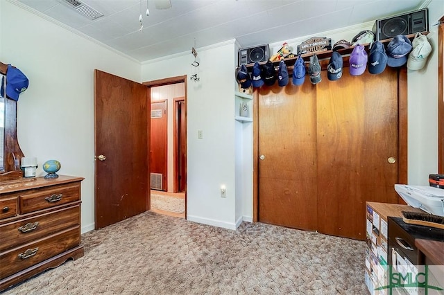 carpeted bedroom featuring visible vents, ornamental molding, baseboards, and a closet