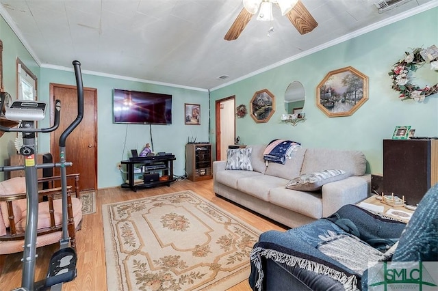 living area featuring crown molding, ceiling fan, visible vents, and wood finished floors