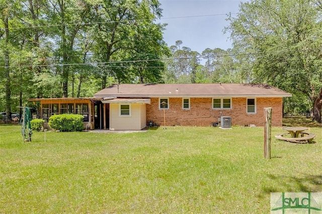back of house featuring central air condition unit, a yard, and a sunroom