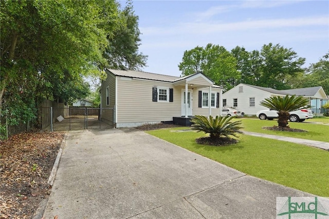 view of front of home featuring a gate, fence, a front yard, and concrete driveway
