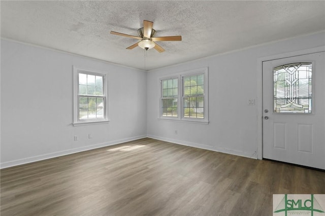 foyer entrance with a textured ceiling, ceiling fan, ornamental molding, and wood finished floors