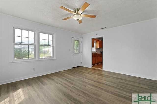 unfurnished living room featuring visible vents, a sink, ceiling fan, and wood finished floors
