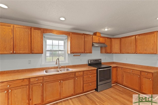 kitchen with brown cabinetry, a sink, stainless steel electric range, and under cabinet range hood
