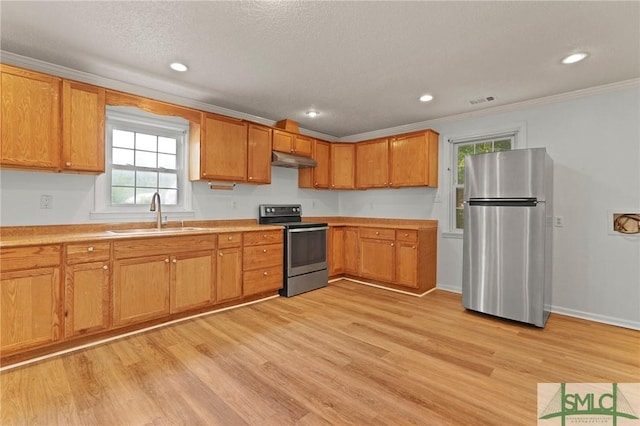 kitchen featuring light countertops, a sink, under cabinet range hood, and stainless steel appliances