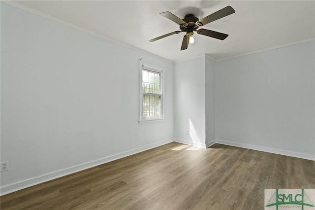 spare room with baseboards, ornamental molding, ceiling fan, and wood finished floors