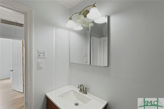 bathroom featuring crown molding, wood finished floors, visible vents, and vanity