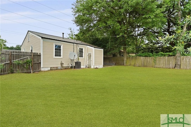 back of property featuring a fenced backyard, central AC unit, and a yard
