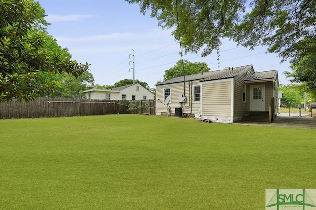 view of yard with fence, entry steps, and central AC