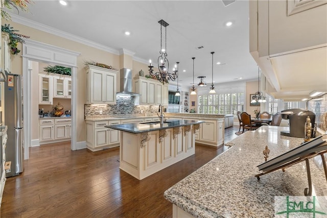 3 Cobham Draw Draw, Pooler, GA 31322 - kitchen with an island with sink, wall chimney range hood, freestanding refrigerator, a chandelier, and cream cabinetry