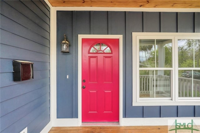property entrance with board and batten siding and a porch