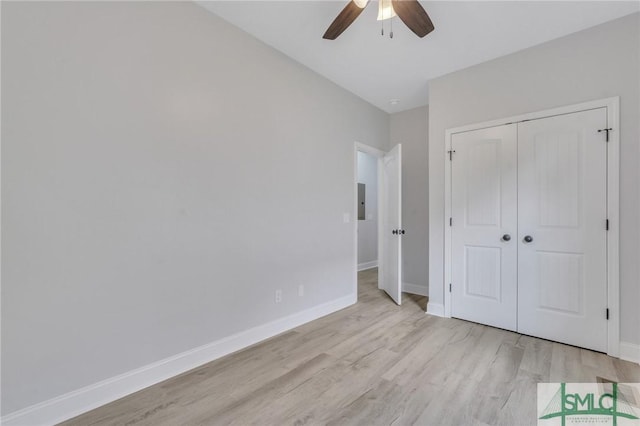 unfurnished bedroom with baseboards, ceiling fan, a closet, and light wood-style flooring