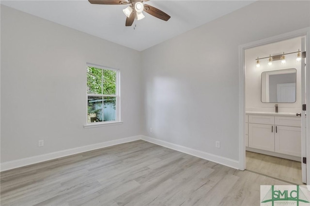 unfurnished bedroom with baseboards, connected bathroom, light wood-style flooring, and ceiling fan