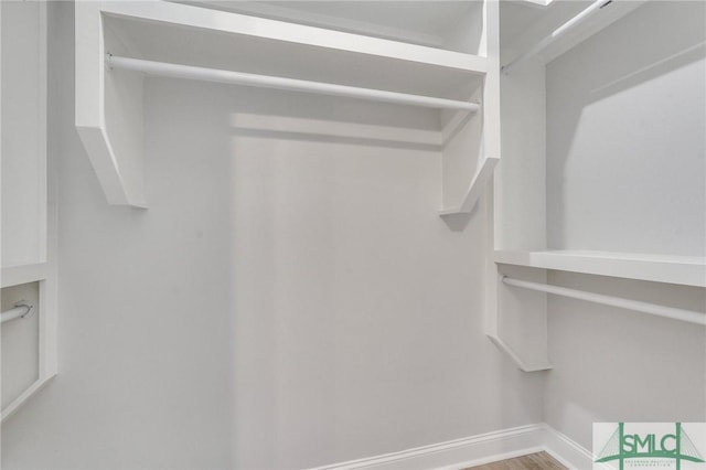walk in closet with wood finished floors