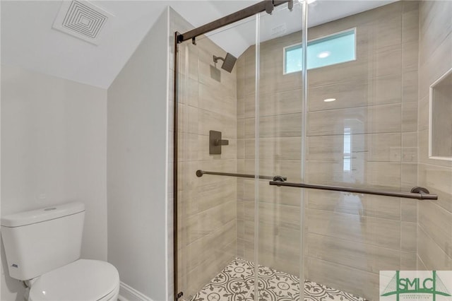 bathroom with toilet, tile patterned floors, lofted ceiling, visible vents, and a stall shower