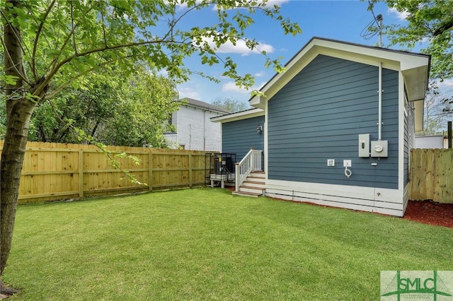 rear view of property featuring a fenced backyard and a yard