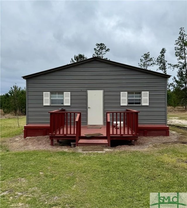 back of house featuring a wooden deck and a yard