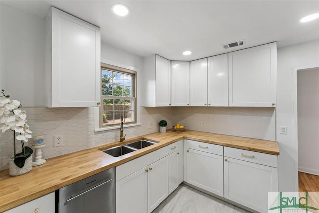 kitchen featuring visible vents, stainless steel dishwasher, butcher block countertops, recessed lighting, and a sink
