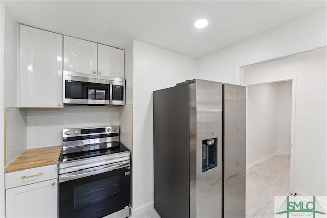 kitchen featuring appliances with stainless steel finishes, white cabinets, decorative backsplash, and recessed lighting