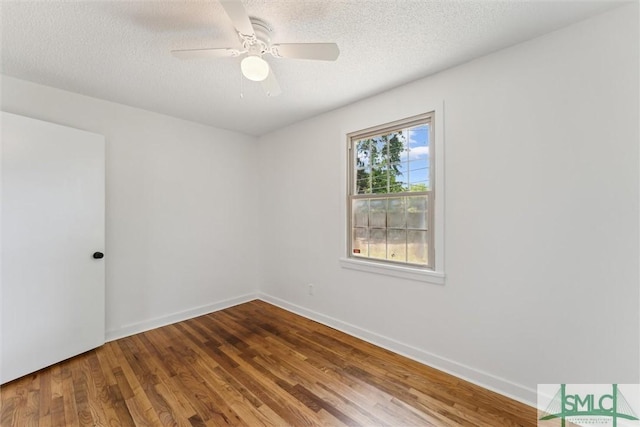 spare room featuring baseboards, a ceiling fan, a textured ceiling, and wood finished floors