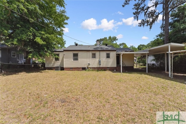 rear view of property with a lawn, a carport, entry steps, and crawl space