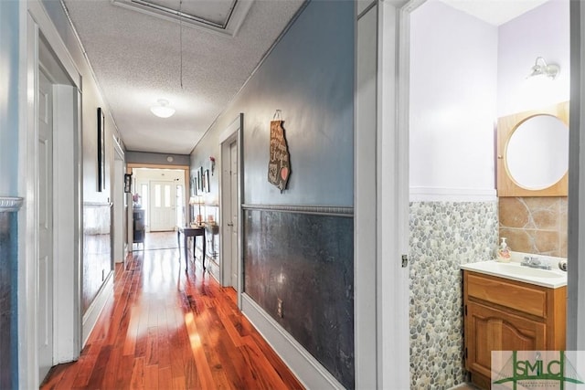 219 N College St, Pembroke, GA 31321 - hall with a textured ceiling, wood finished floors, and attic access