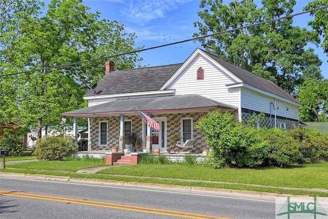 219 N College St, Pembroke, GA 31321 - farmhouse-style home featuring a chimney, a porch, a front lawn, and stone siding