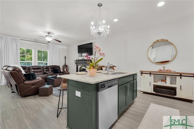 kitchen featuring a fireplace, dishwasher, a sink, ceiling fan with notable chandelier, and open floor plan