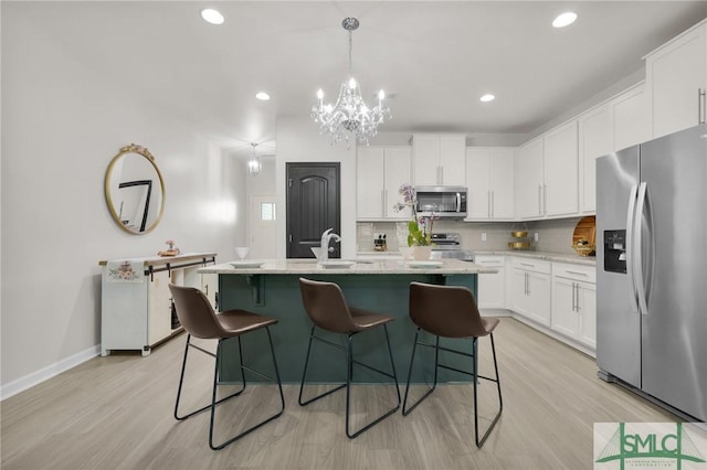 kitchen featuring appliances with stainless steel finishes, backsplash, white cabinetry, and a chandelier
