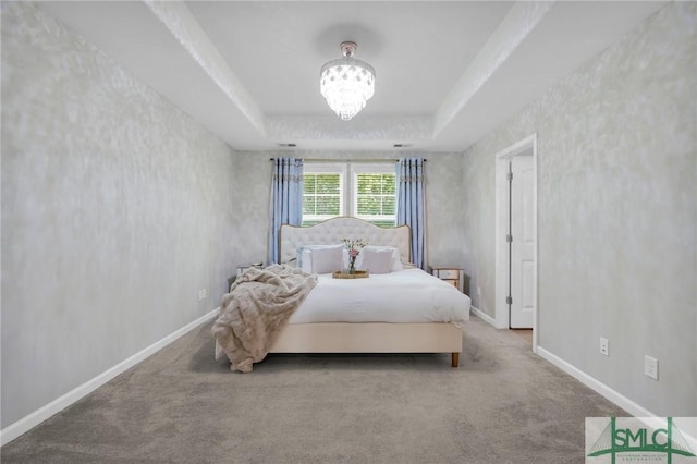 bedroom with a raised ceiling, baseboards, and carpet