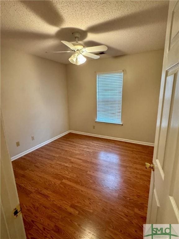 unfurnished room featuring baseboards, a ceiling fan, a textured ceiling, and wood finished floors