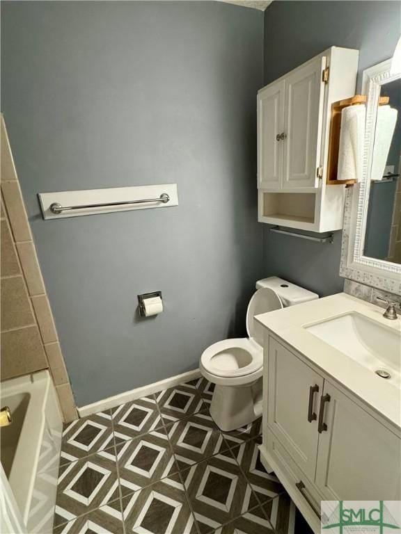 bathroom featuring toilet, a tub, and vanity
