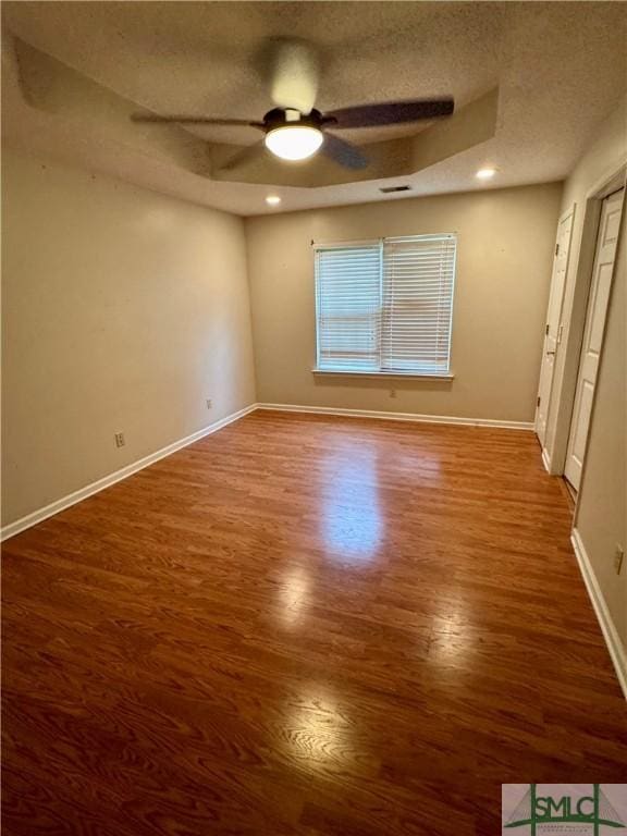 unfurnished bedroom featuring baseboards, a ceiling fan, a textured ceiling, and wood finished floors