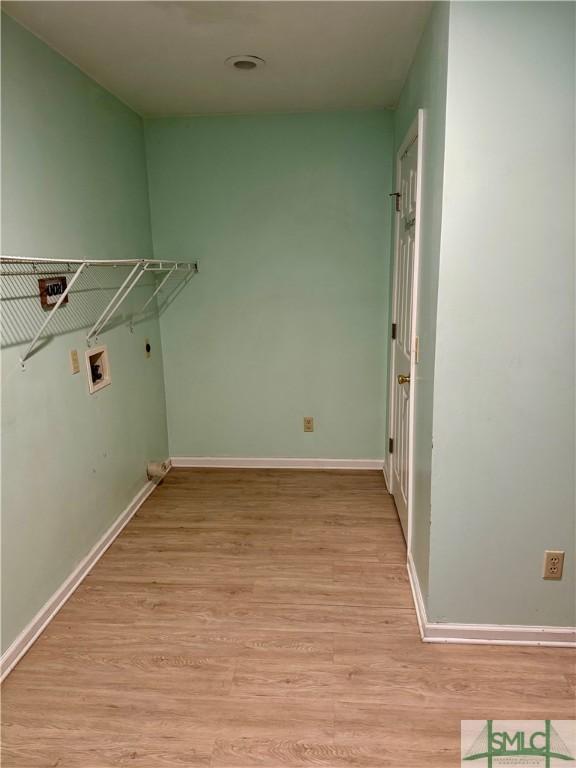 clothes washing area featuring laundry area, hookup for a washing machine, light wood-style flooring, baseboards, and hookup for an electric dryer