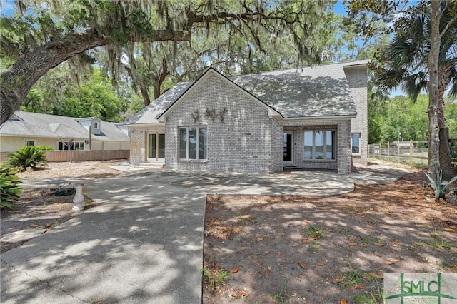 1443 Gillican Ave NE, Townsend, GA 31331 - view of front of property with concrete driveway, brick siding, fence, and a patio