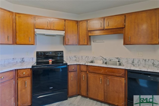 kitchen with under cabinet range hood, a sink, black appliances, and light countertops