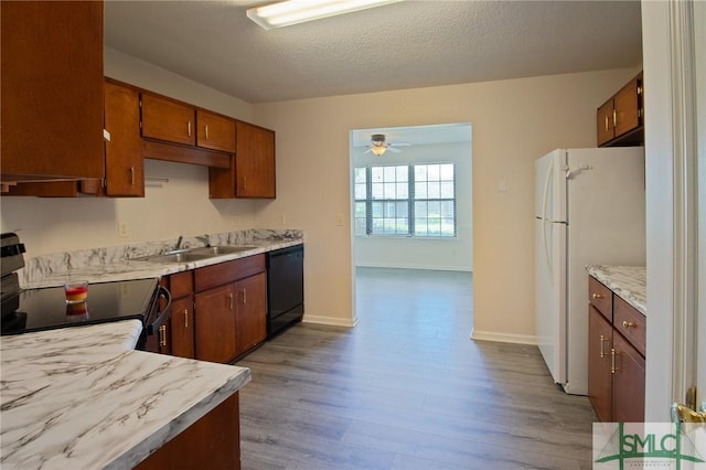 kitchen featuring electric range oven, light countertops, dishwasher, dark wood finished floors, and freestanding refrigerator