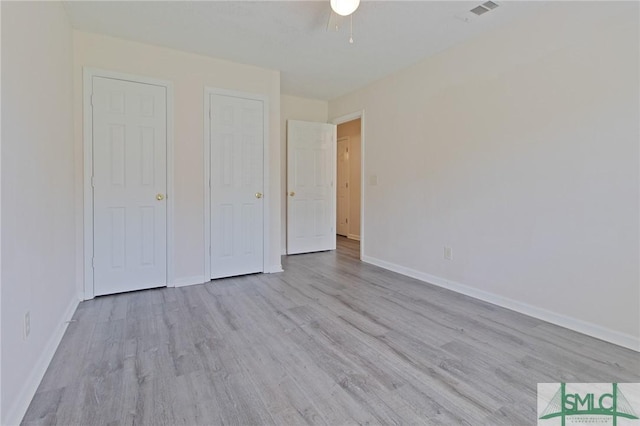 unfurnished bedroom with baseboards, visible vents, and wood finished floors