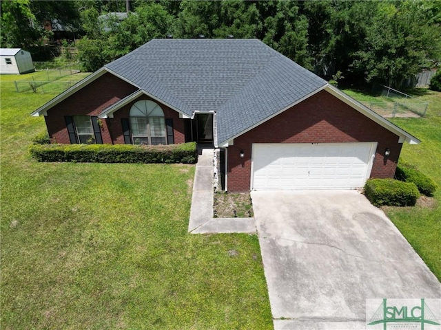 view of front facade with a front yard, brick siding, fence, concrete driveway, and an attached garage