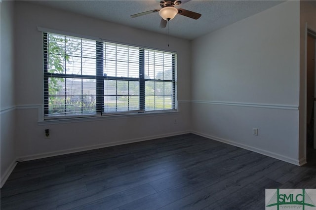 spare room with a ceiling fan, baseboards, dark wood-style floors, and a textured ceiling