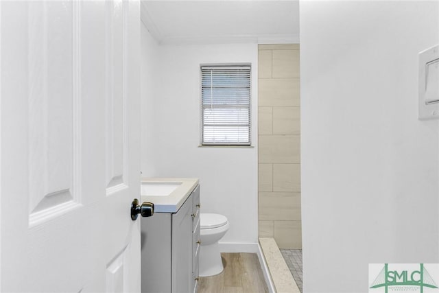 819 W 51st St, Savannah, GA 31405 - full bathroom featuring toilet, vanity, wood finished floors, a tile shower, and ornamental molding